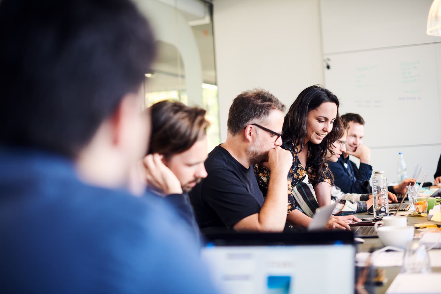 A person sitting alone in an empty lecture hall with feet up, reading – symbolizing independent thinking, learning and the confidence to take a different perspective.