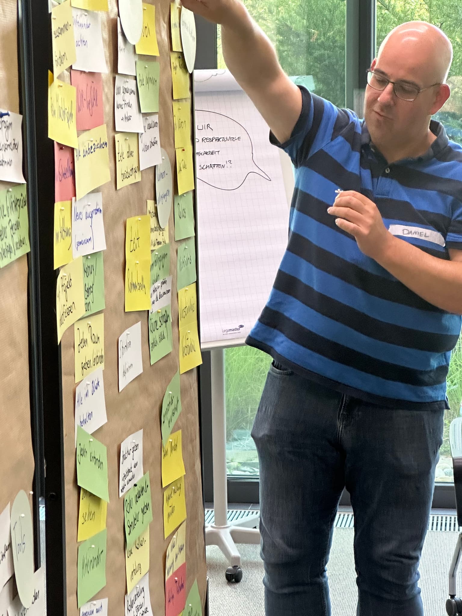 Man in front of a wall mit many post its